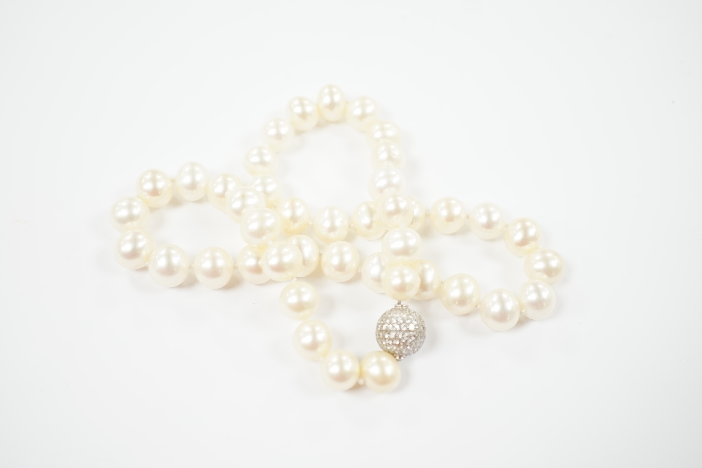 A modern single strand cultured pearl necklace with pave set diamond mounted spherical yellow metal clasp, 44cm.